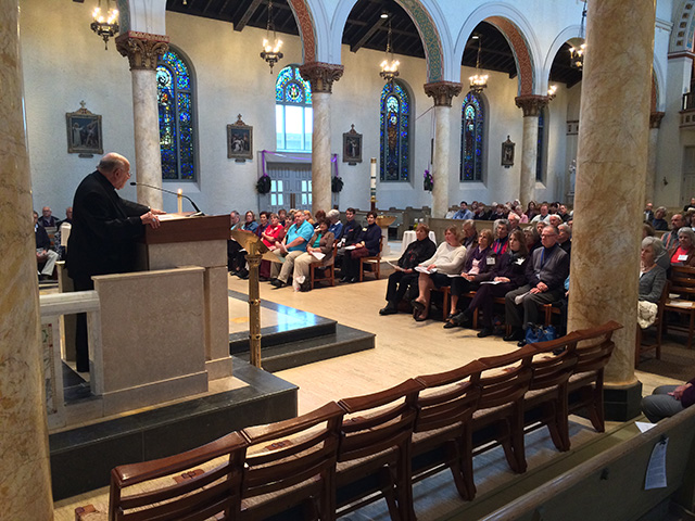father rooney speaking in a church to an audience